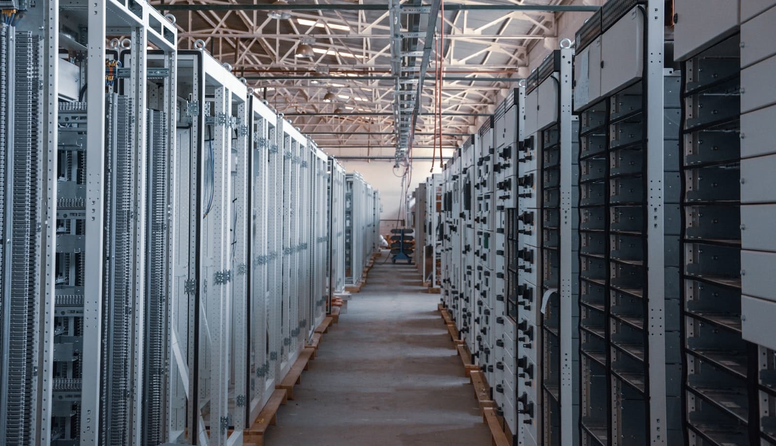 Allée d'une salle de serveurs, baies métalliques alignées