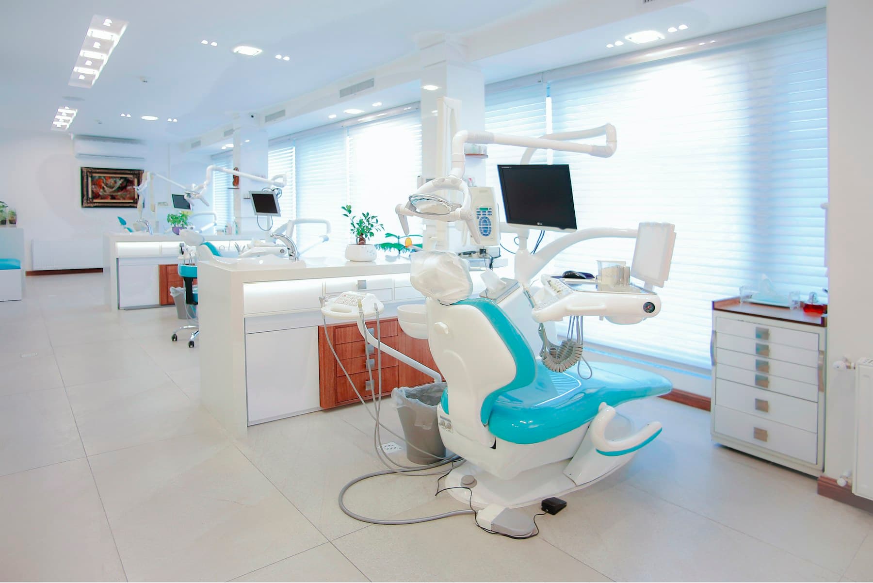 Une salle de soins claire, fauteuil vert d'eau prêt pour le patient suivant